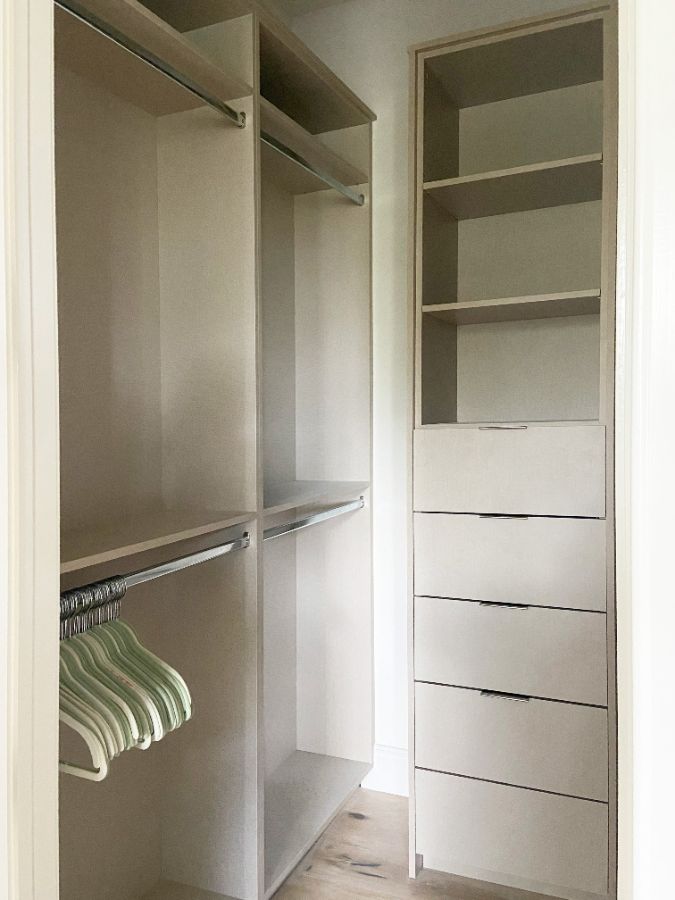 White closet with hanging rods and drawers