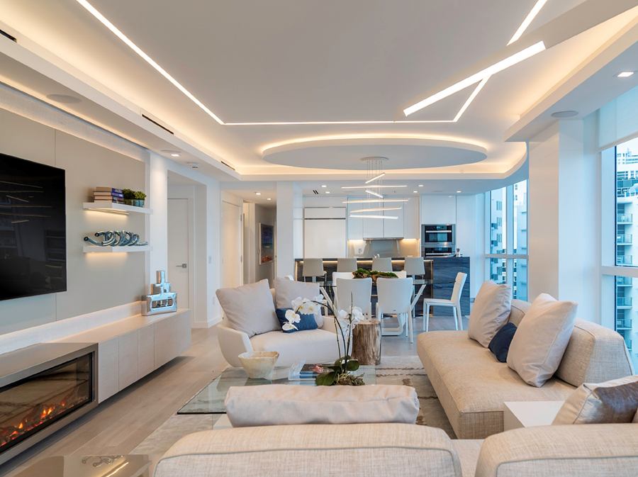 Miami apartment living room with a custom TV unit, fireplace and kitchen by VIPWoodwork