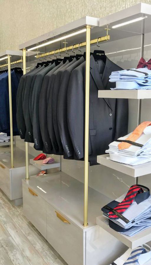 Suit display with brass rails and shirt shelves